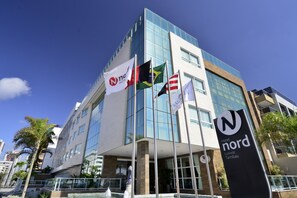Um hotel moderno com vários pavilhões, incluindo o pavilhão do Nordic Hotel, e uma placa grande com a palavra 'Nord'.