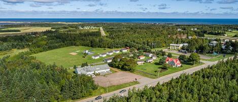 Vista aérea de una zona residencial con casas, una carretera y un paisaje boscoso.