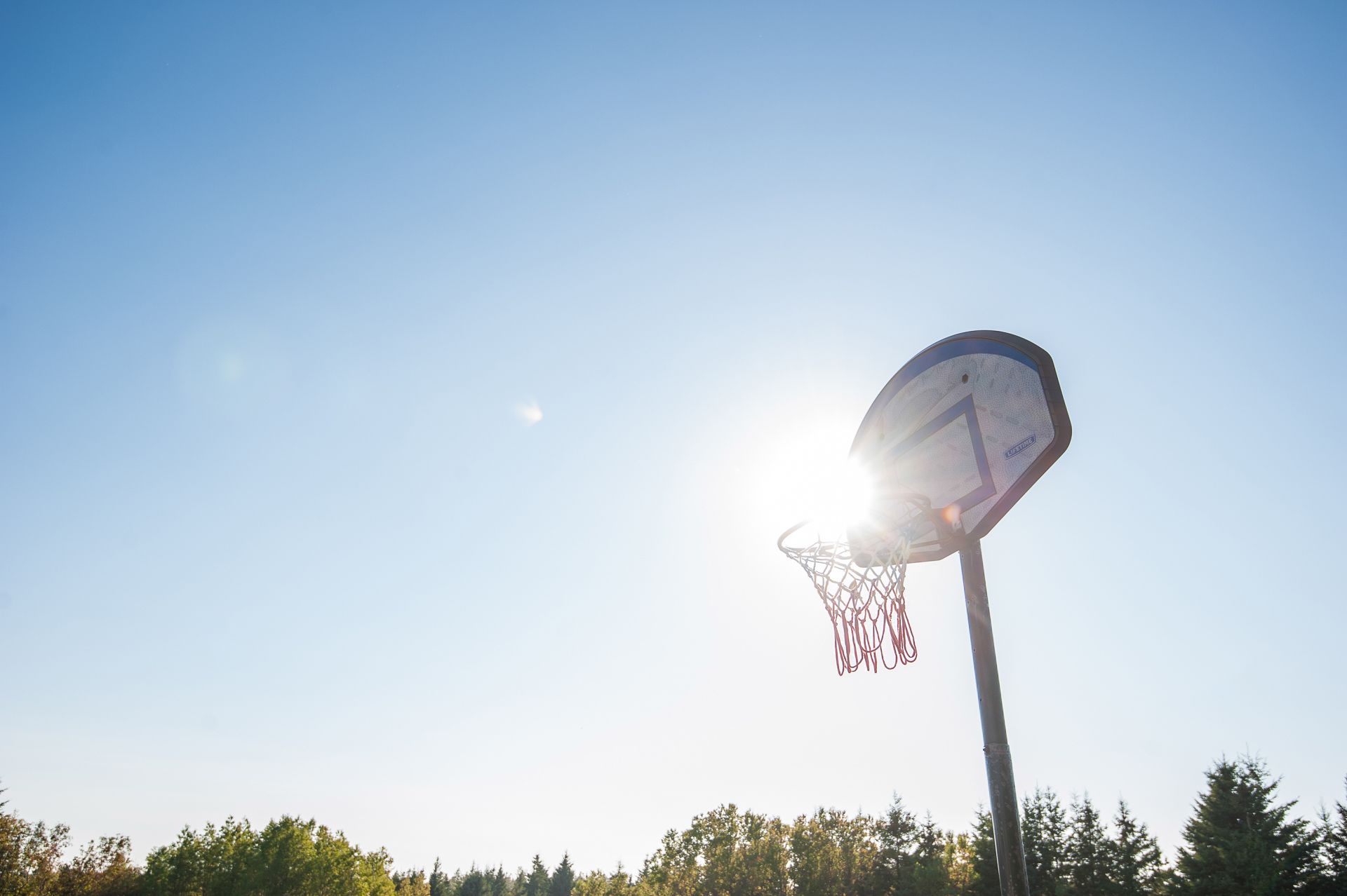 Een basketbalring met een heldere lucht op de achtergrond.