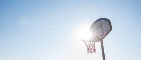 Een basketbalring met een heldere lucht op de achtergrond.