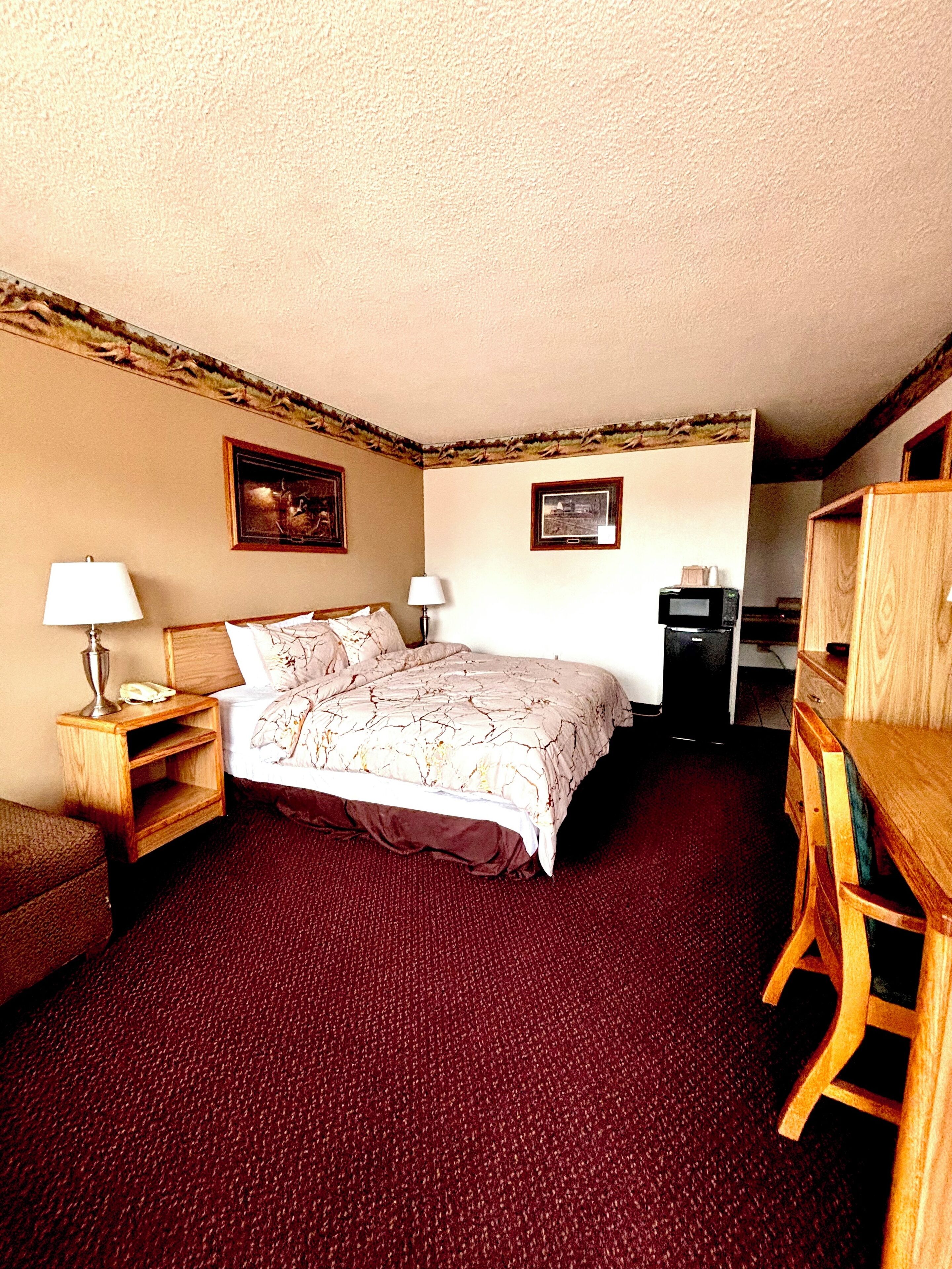 Une chambre à coucher avec un lit, deux tables de chevet, un bureau et une chaise.