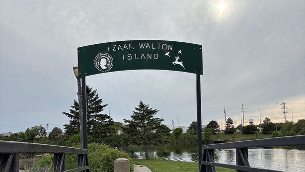 Un paseo marítimo de madera que conduce a un letrero que dice "Izak Walton Island".