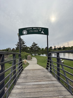 Ein Holzsteg führt zu einem Schild mit der Aufschrift 'Izak Walton Island'.