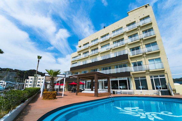 A hotel with a swimming pool, outdoor seating, and a multi-story building with balconies. - THE ONJUKU terrace (Onjuku)
