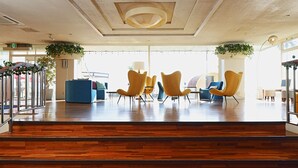 A spacious lobby with wooden flooring, modern yellow chairs, and a blue sofa. - THE ONJUKU terrace (Onjuku)