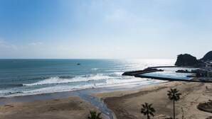 A beach with a clear view of the ocean, a sandy shore, and a rocky outcrop in the distance. - THE ONJUKU terrace (Onjuku)