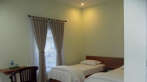A hotel room with two beds, a desk, and a chair.