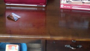 A person sitting at a desk with a red VAIO laptop and a brochure.