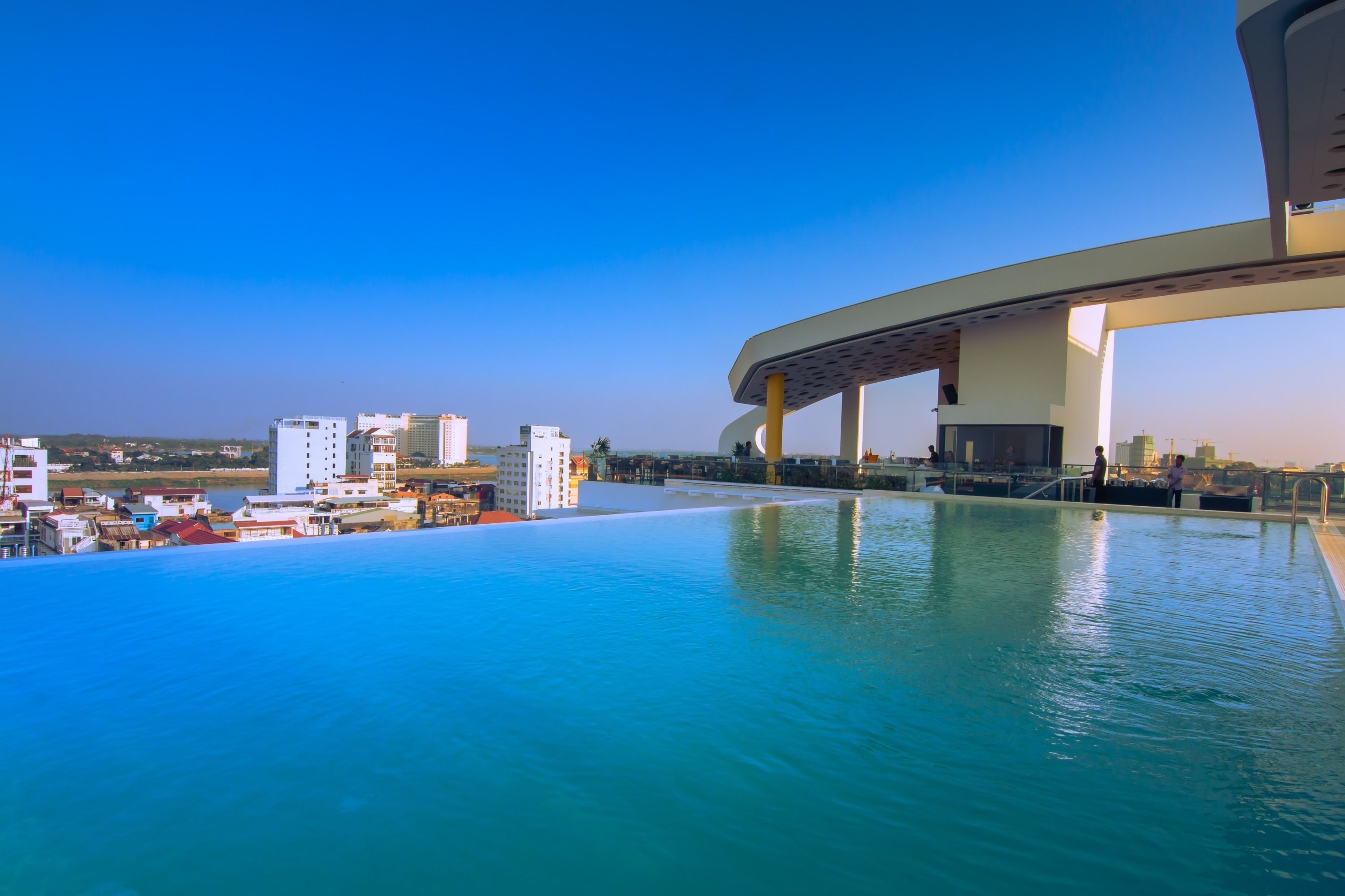 Una piscina infinita con vistas a un paisaje urbano y un puente.