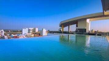 Una piscina infinita con vistas a un paisaje urbano y un puente.