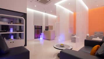 A modern hotel lobby with a reception desk, seating area, and a decorative wall with vertical lines.