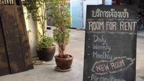 A sign for a room for rent with daily, weekly, and monthly options, and amenities including an air conditioner, water heater, refrigerator, and TV. - Non Du Lay Guesthouse (Ko Lanta)