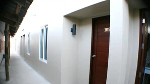 A corridor with a door marked "102" and a small step leading to it. - Non Du Lay Guesthouse (Ko Lanta)