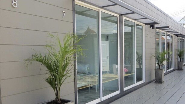 A modern building with large glass windows and a flat roof. - Non Du Lay Guesthouse (Ko Lanta)