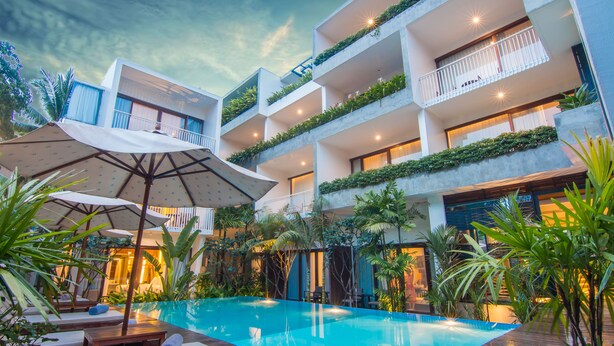 A modern hotel with a rooftop pool, outdoor seating, and lush greenery. - Apsara Residence Hotel (Siem Reap)