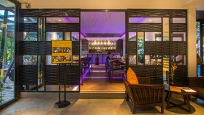 A modern bar area with a wooden partition, bar stools, and a well-lit interior. - Apsara Residence Hotel (Siem Reap)