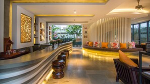 A modern lobby with a curved reception desk, seating area with sofas, and a view of the outdoors. - Apsara Residence Hotel (Siem Reap)