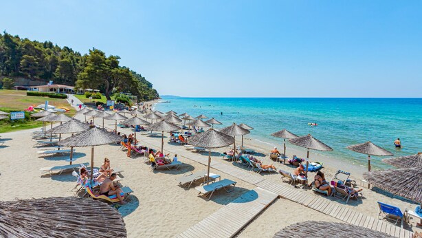 A beach with sun loungers, umbrellas, and a clear blue sea. - Elani Bay Resort (Kassandra)