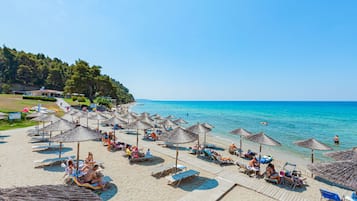 Am Strand, weißer Sandstrand, Liegestühle, Sonnenschirme