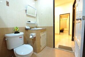 A bathroom with a toilet, sink, and mirror. - Ruankasalong Hua Hin Holiday House (Hua Hin)