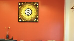 A living room with a sofa, a coffee table with magazines, a decorative wall piece, and a cabinet. - Ruankasalong Hua Hin Holiday House (Hua Hin)