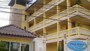 A yellow building with a sign reading "Plus Place". - Pius Place (Pattaya)