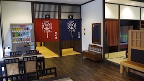 A room with a vending machine, a tatami mat area, and a traditional Japanese sliding door. - Urayu Ryokan Urashima (Onomichi)