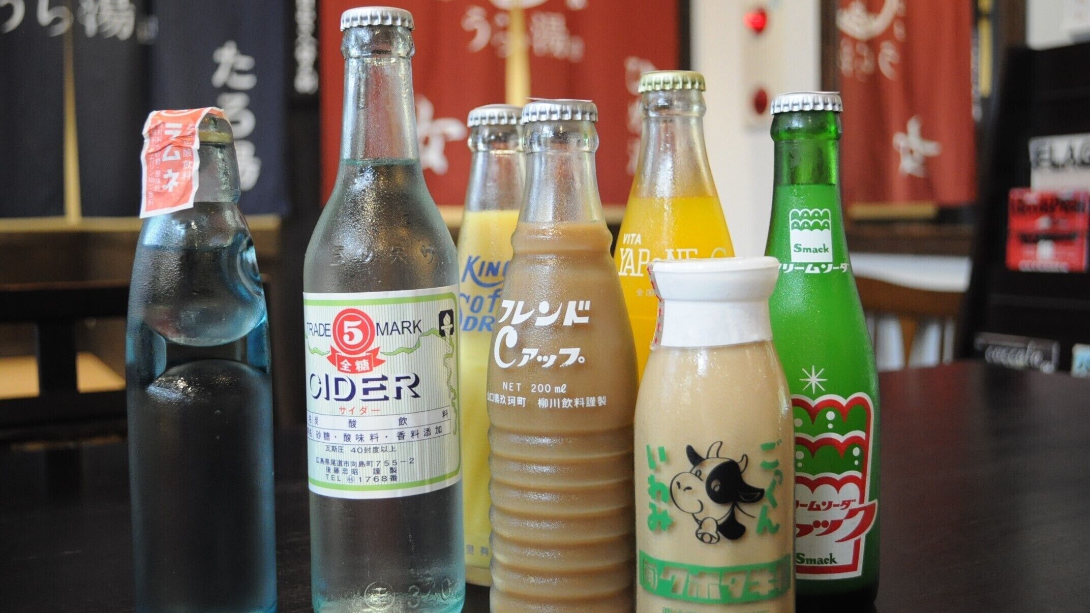 On peut voir une variété de bouteilles de boissons sur le comptoir d’un bar.