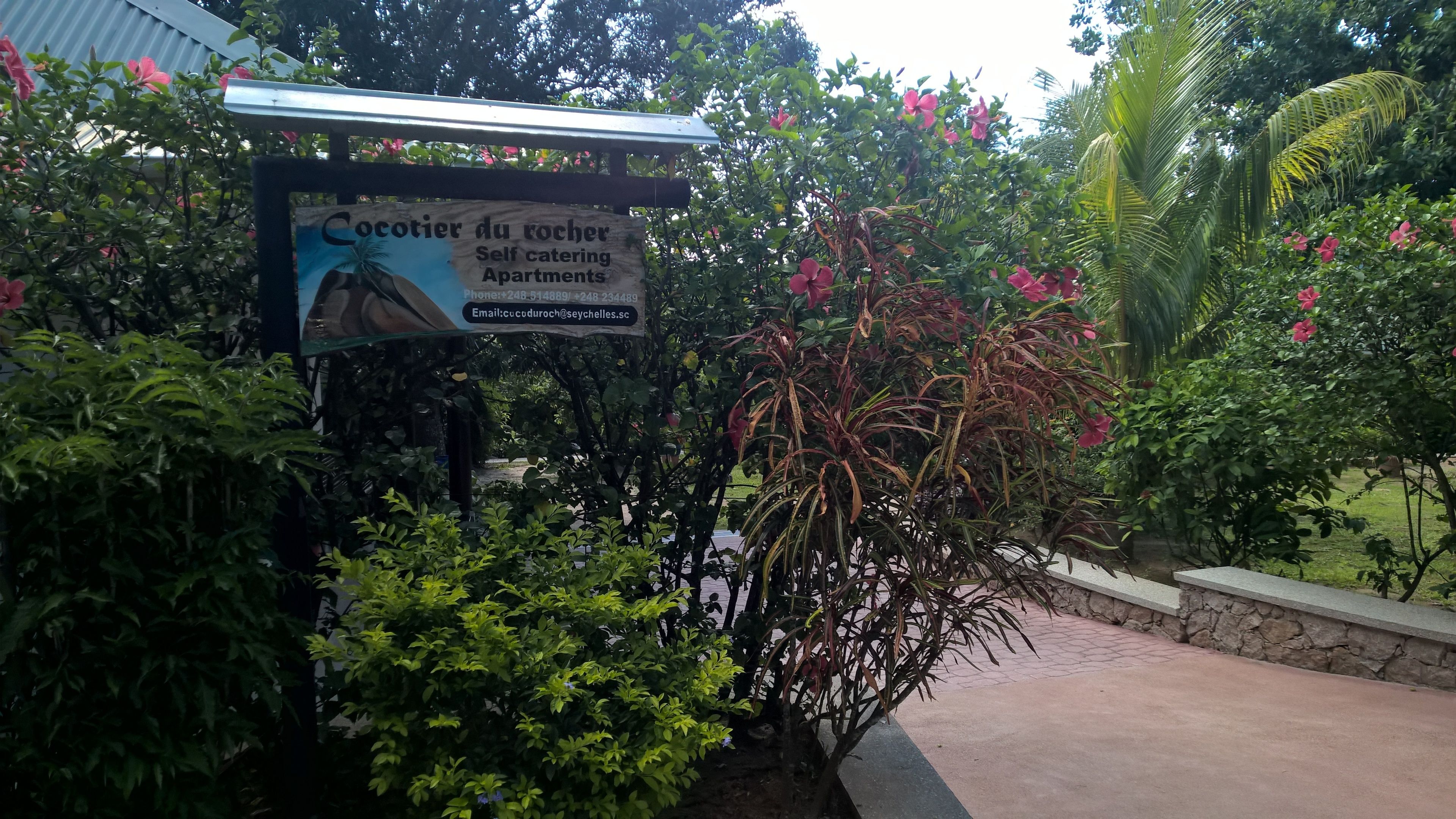 Señal para los apartamentos vacacionales 'Cocotier du Roch' con datos de contacto.