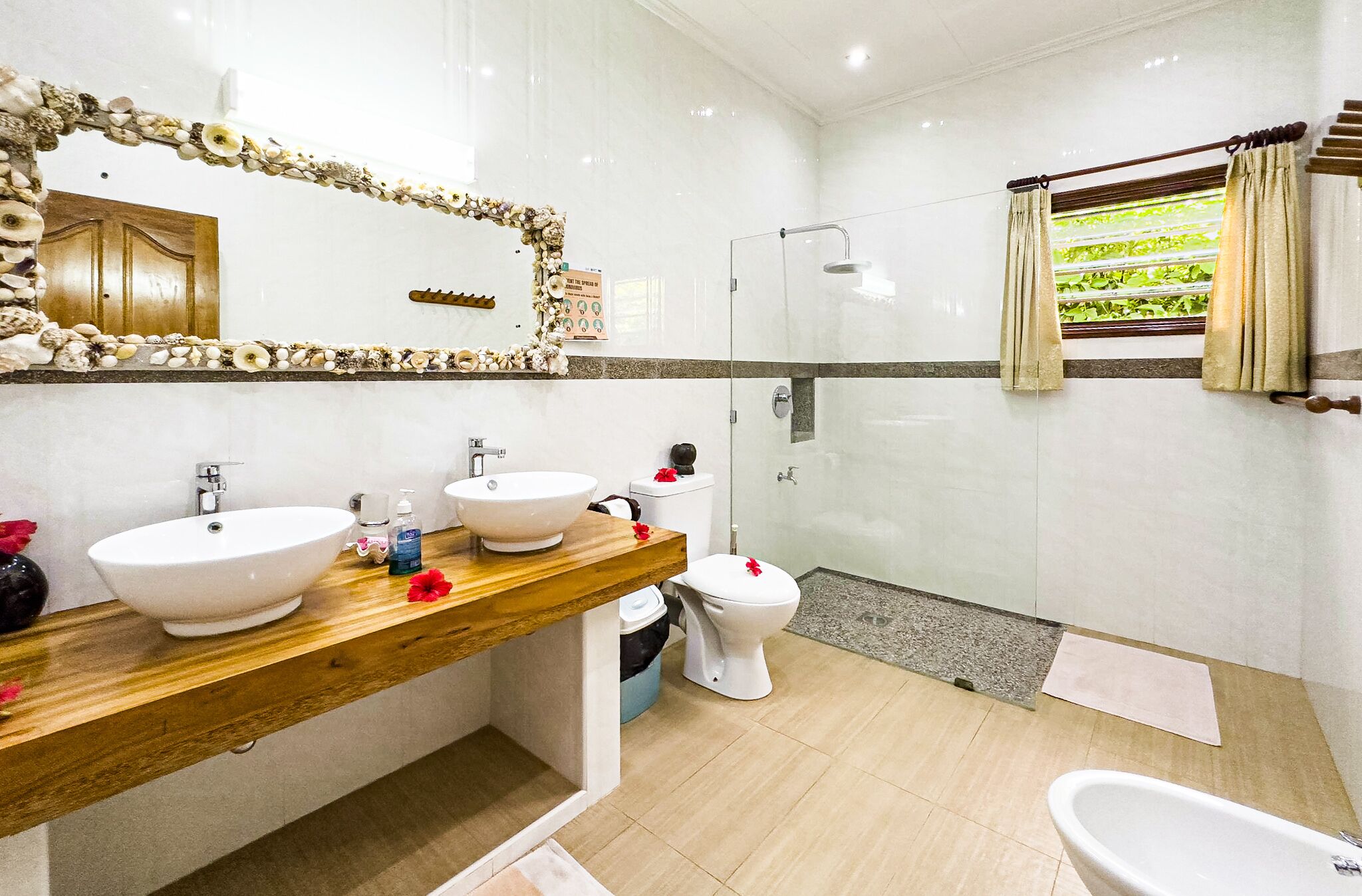 A modern bathroom with two sinks, a toilet, a shower, and a bathtub.