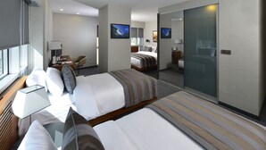 Een hotelkamer met twee bedden, een bureau, een stoel en een grote spiegel.