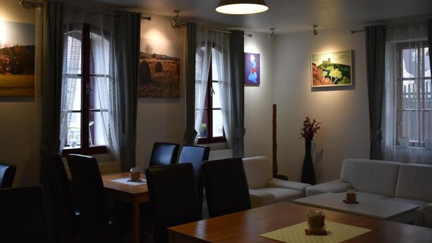 Een eetruimte met een houten tafel, stoelen en een hanglamp.
