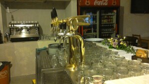 Een bar met een biertap, een koffieapparaat en een Coca-Cola koelkast.