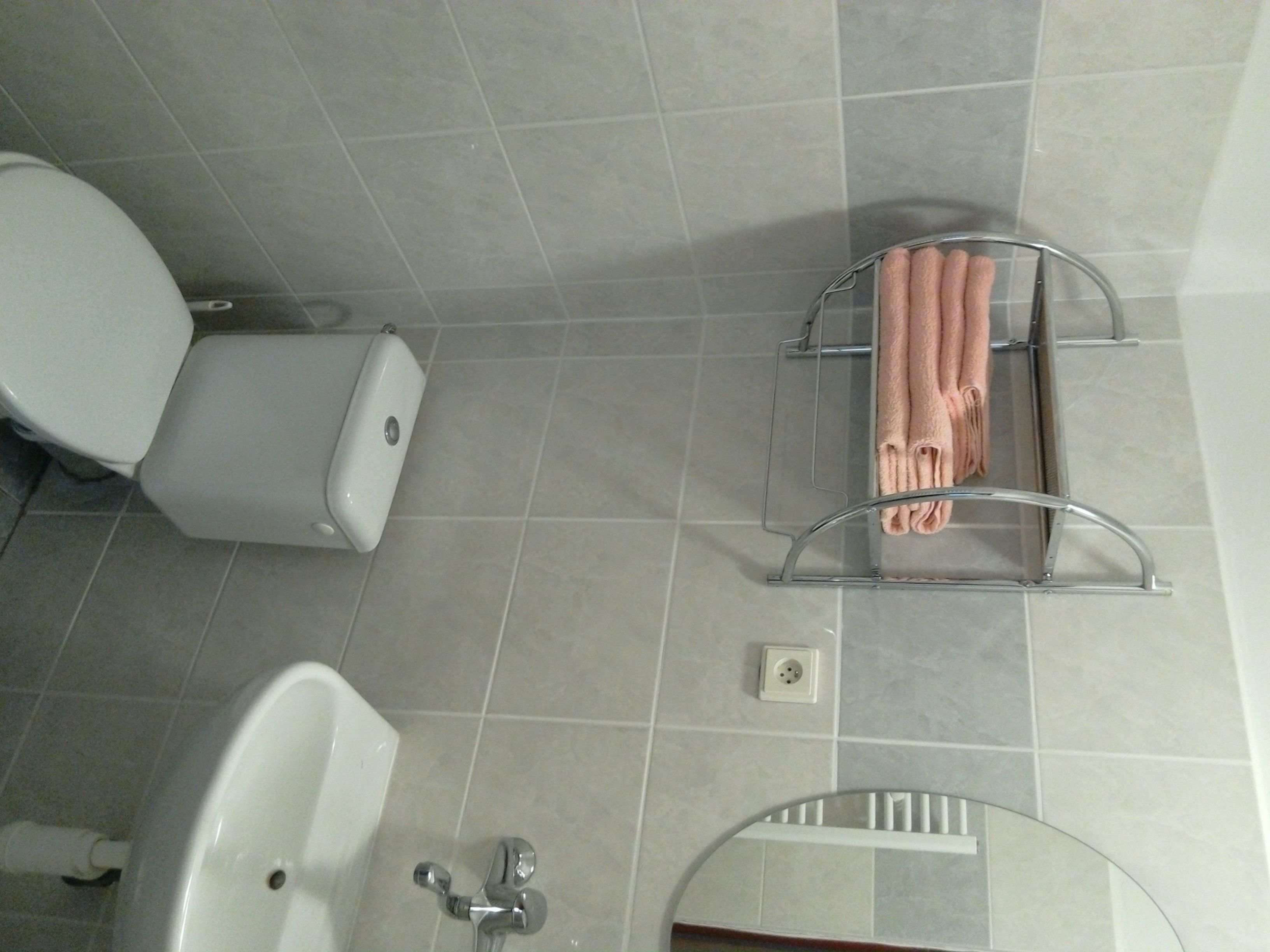 Une salle de bain équipée de toilettes, d’un lavabo et d’un porte-serviettes.