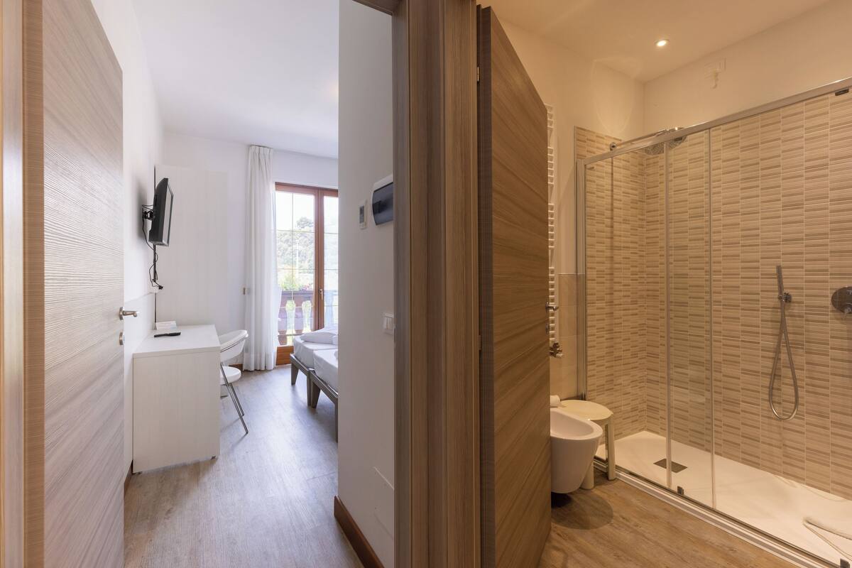 Ein modernes Badezimmer mit einer Duschkabine, einer Toilette und einem Waschbecken.