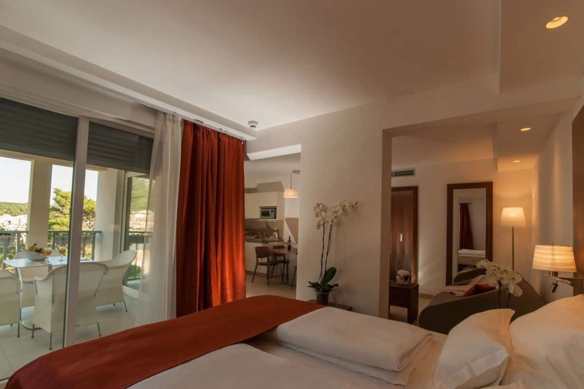 Hotellihuone, jossa on sänky, työpöytä, tuoli ja näkymä ulos.