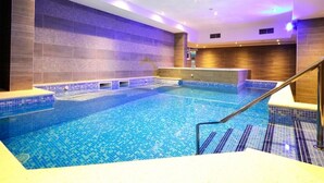 An indoor swimming pool with tiled walls and a clear blue pool. - Aparthotel Miramare (Makarska)