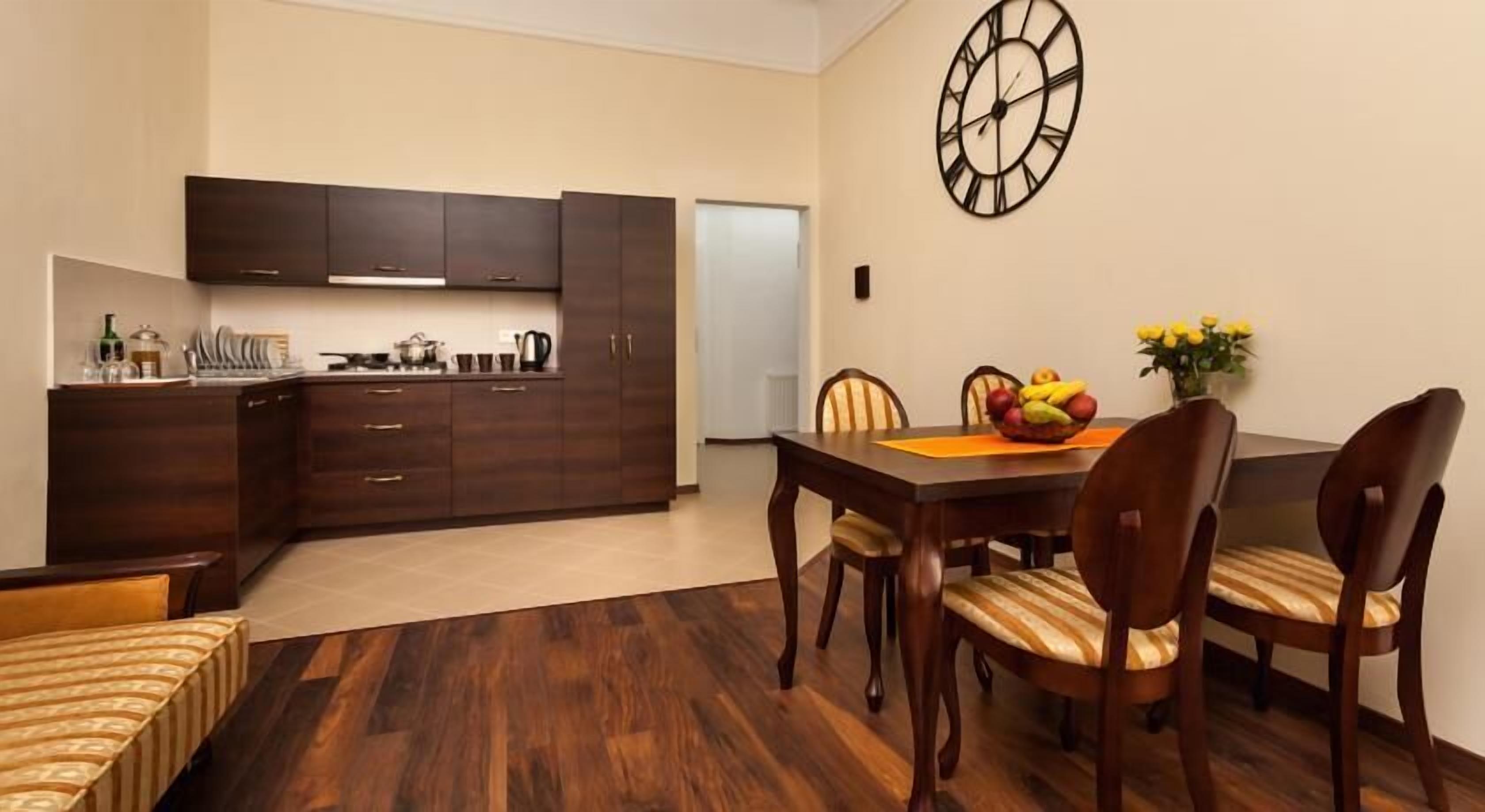 A modern kitchen with dark wooden cabinets and a dining area with a wooden table and chairs.