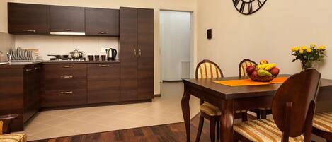 A modern kitchen with dark wooden cabinets and a dining area with a wooden table and chairs.