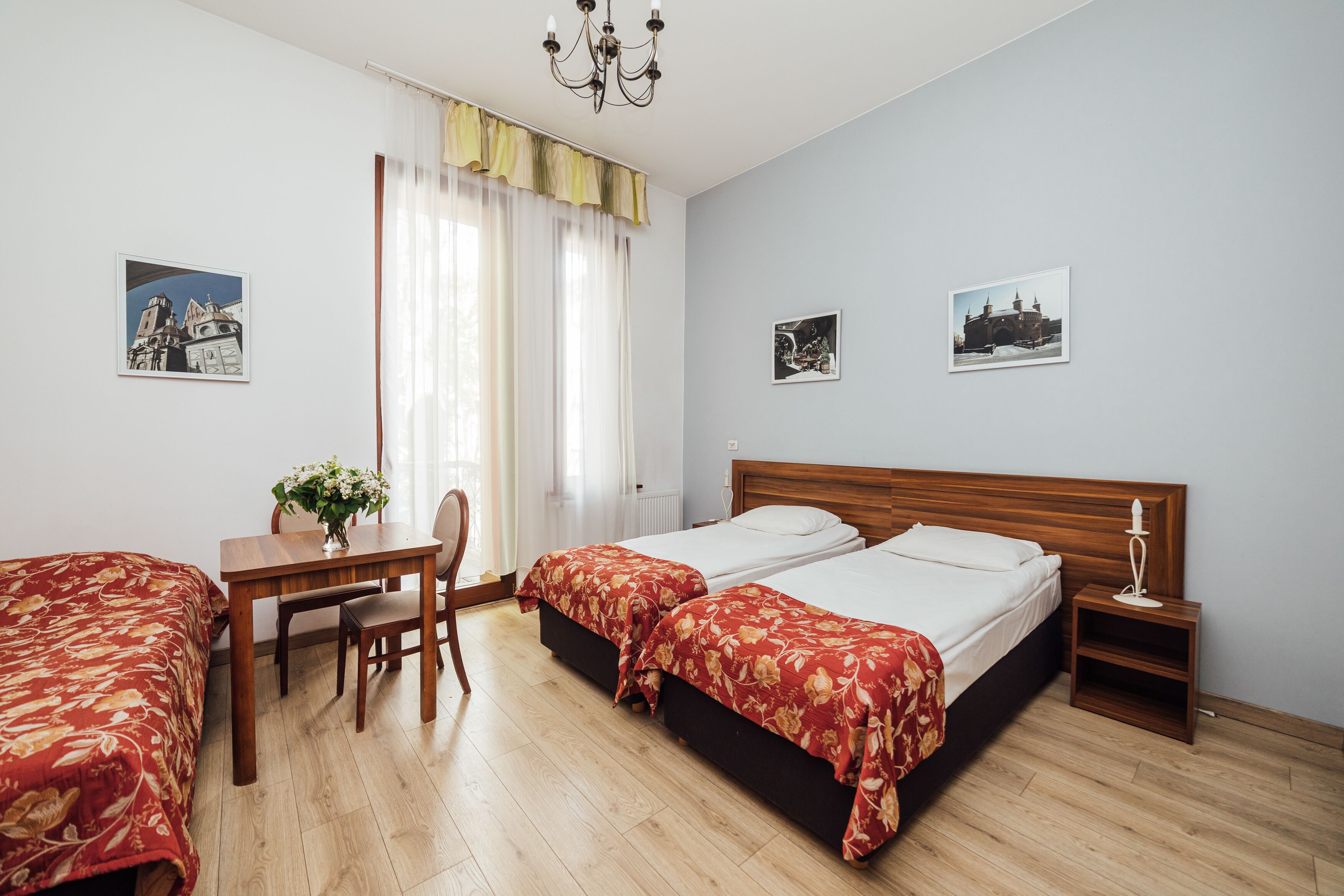A hotel room with two beds, a desk, and a chair.
