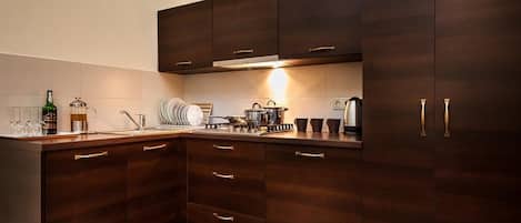 A modern kitchen with dark wood cabinets, stainless steel appliances, and a tiled backsplash.