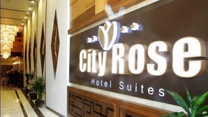 A hotel entrance with a sign reading "City Rose Hotel Suites" and a modern interior design. - City Rose Hotel Suites (Amman)
