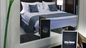 A modern hotel room with a large bed, a decorative wall, a nightstand, and a mirror. - City Rose Hotel Suites (Amman)