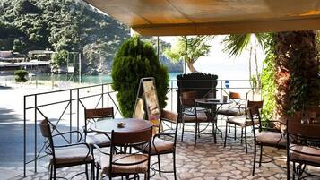 Une terrasse extérieure avec un sol en pierre, des chaises et des tables en métal.