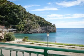 Une vue sur la côte, avec une promenade dallée, un lampadaire et une falaise rocheuse.