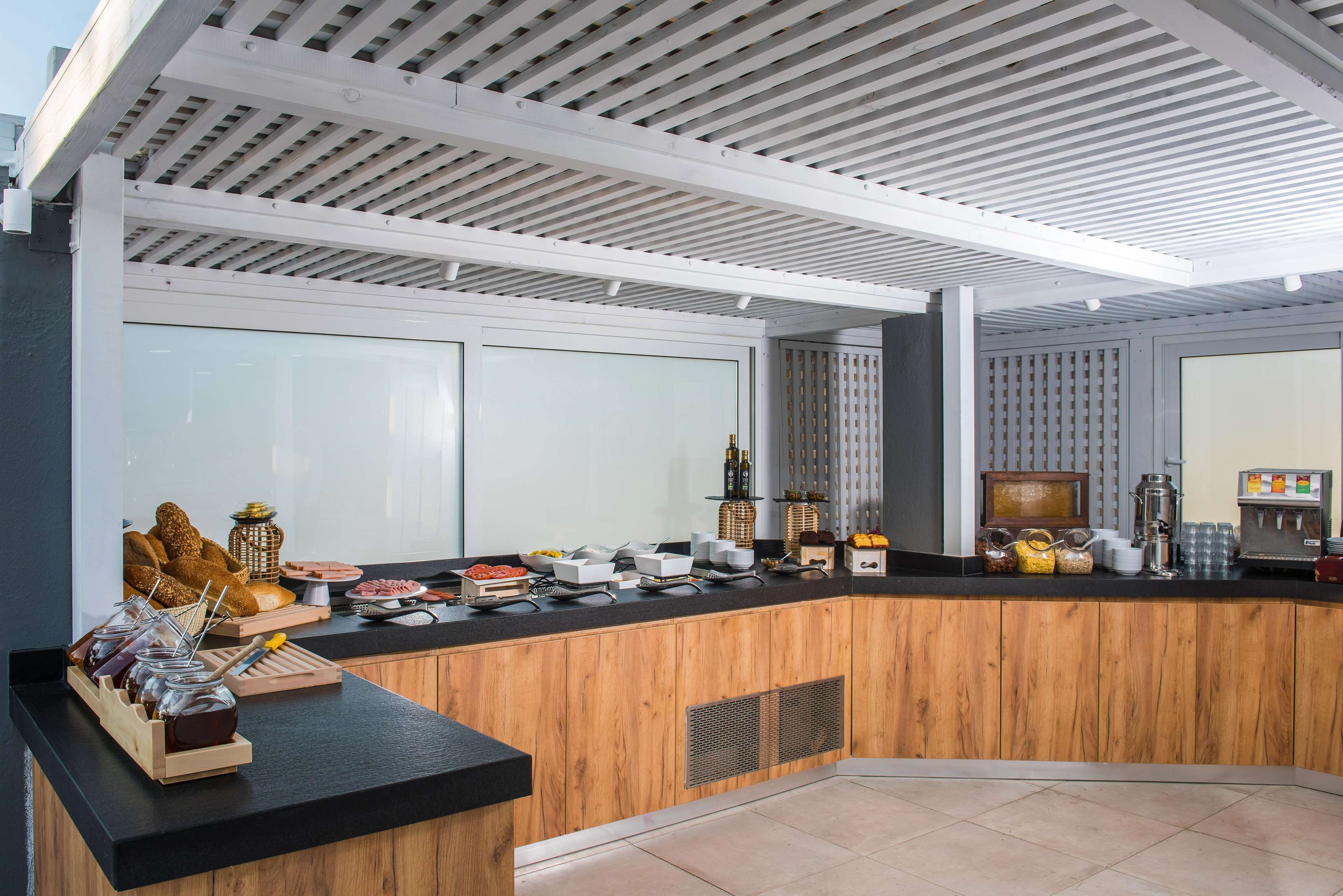 Een moderne receptie met een houten balie, glazen scheidingswanden en diverse horecapunten.