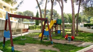 A playground with swings, slides, and a small red toy car. - Catalonia Park Apartments (Salou)