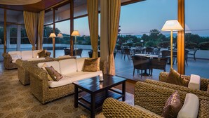 A cozy lounge area with wicker furniture, a coffee table, and a view of the outdoors.
