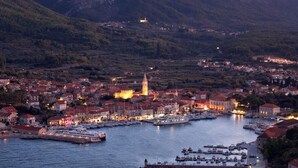 A coastal town with a marina, historic buildings, and a prominent church tower.