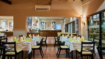 A restaurant with tables set for dining, chairs, and a counter area.